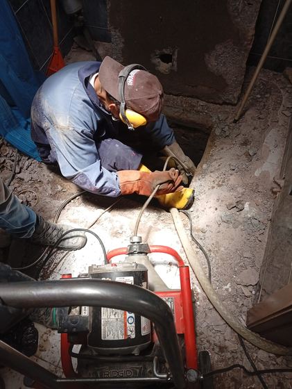 Técnico trabajando en fosa de instalación de bomba